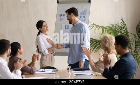 Smiling executive shaking successful Arabic businesswoman hand at briefing Stock Photo