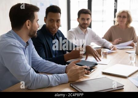 Diverse colleagues discussing project at corporate meeting in boardroom Stock Photo