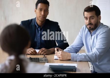 Two diverse hr manager listening to candidate at job interview Stock Photo