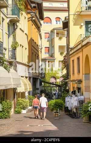 GARDONE RIVIERA, ITALY - SEPTEMBER 2018: Two people walking down a narrow street in Gardone Riviera on Lake Garda. Stock Photo