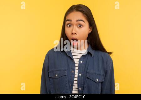 Portrait of funny amazed girl in denim shirt standing with mouth open in surprise and looking shocked at camera, astonished by unbelievable success. i Stock Photo