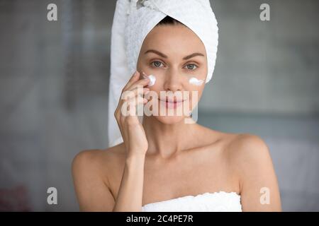 Beautiful young female do morning facial procedures in bathroom Stock Photo
