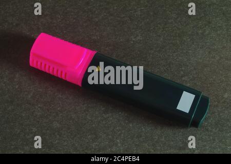 Pink wide stationery marker for highlighting text and drawing on dark gray background close-up. Stock Photo