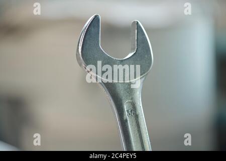 Close-up of metal wrench used to turn bolts and nuts in workshop, mechanics tool Stock Photo