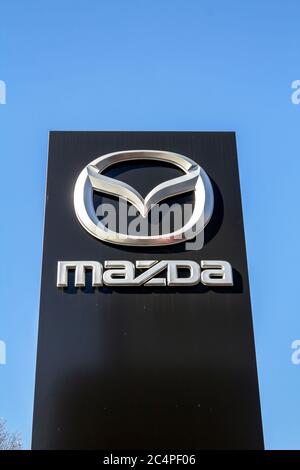 Nuremberg, GERMANY: Mazda dealership sign against blue sky. Mazda is a Japanese automaker and produces over 1 million vehicles per year. Stock Photo