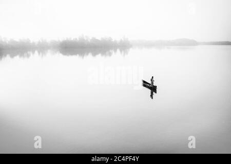 lone man fishing in river backwater Stock Photo