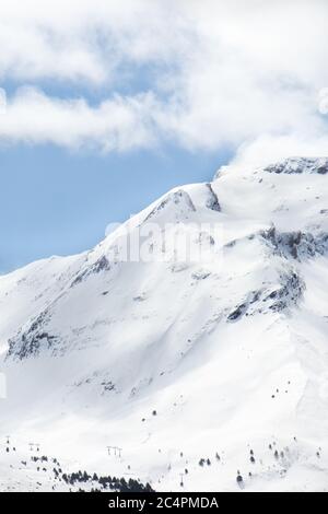 Snow-covered mountain side with ski slope Stock Photo