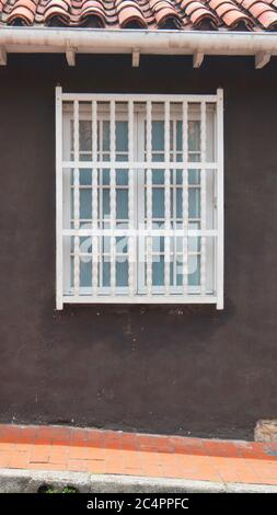 White wooden window on a wall brown background with red tile roof in vertical format Stock Photo