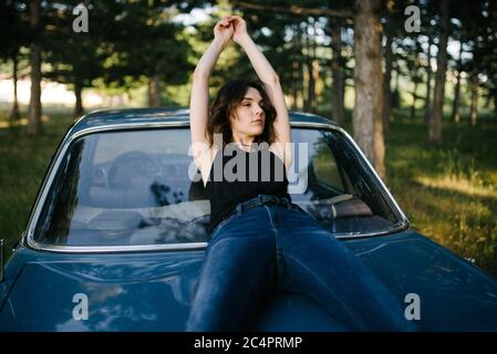 Portrait of a hipster woman sitting on the car Stock Photo