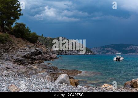 A rocky terrain by the water with clody sky Stock Photo