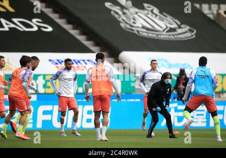 Manchester City Fitness Coach Lorenzo Buenaventura takes the warm up whilst wearing a face mask before the FA Cup quarter final match at St James' Park, Newcastle. Stock Photo