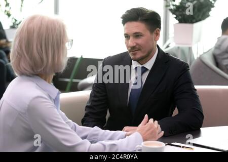 Two successful business people meeting in cafe and communicating Stock Photo