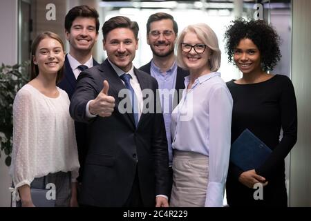 Successful adult business man with diverse team of happy workers Stock Photo