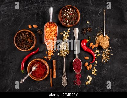 Colorful spices in spoons on dark stone table. Stock Photo