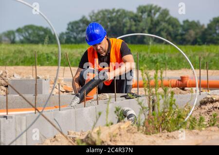 Construction or site manager checking or overseeing the foundations of the new house, buidling or construction Stock Photo