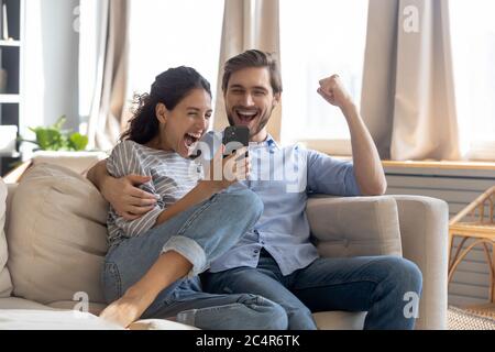 Overjoyed surprised young couple looking at phone screen Stock Photo