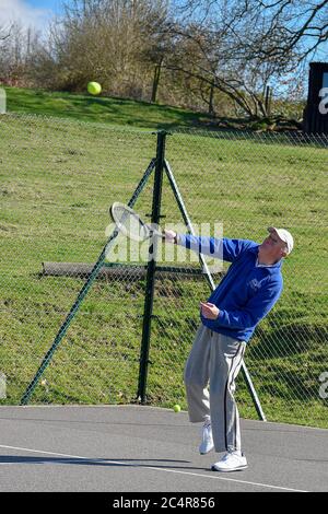 Retired elderly gentleman playing tennis. Stock Photo