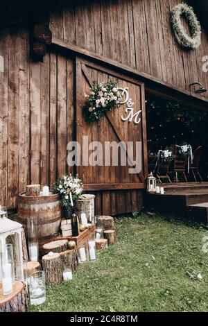 Close up of wooden rural restaurant with flowers, candles and paper letters. Beautiful view of wedding decoration and composition. Concept of style an Stock Photo