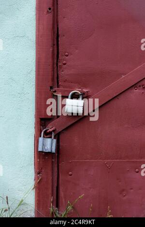 Two gray locks on a burgundy door. Perfect protection. Stock Photo