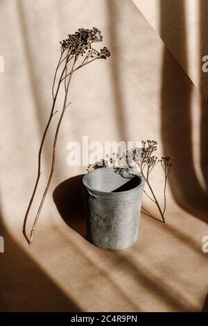 Abstract creative minimal composition with a clay pot and dry grass against kraft paper. Natural and ecological products concept. Stock Photo