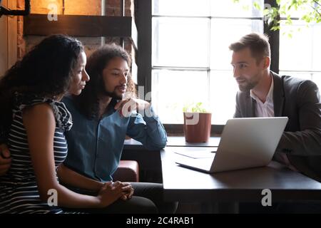 Agent showing to african spouses new house project online presentation Stock Photo