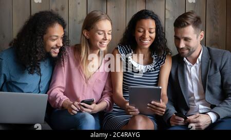 African woman showing funny video to friends using tablet device Stock Photo