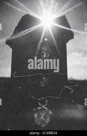 Fine 70s vintage black and white photography of a sun shining behind a house. Stock Photo