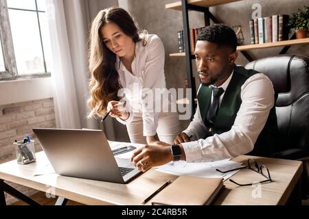 Happy young woman and handsome man working together in the office Stock Photo