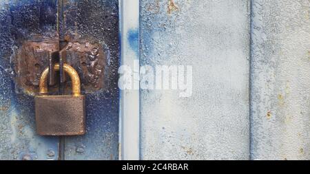Old Lock hangs on a garage door with copyspace on the right. Locked content informational concept. Safe data concept Stock Photo