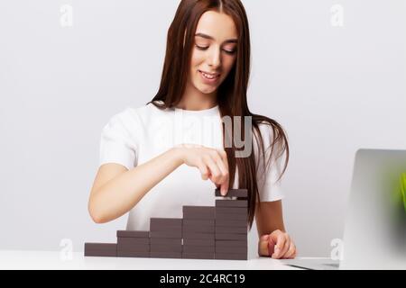 Beautiful young woman demonstrates on subjects the concept of business development Stock Photo