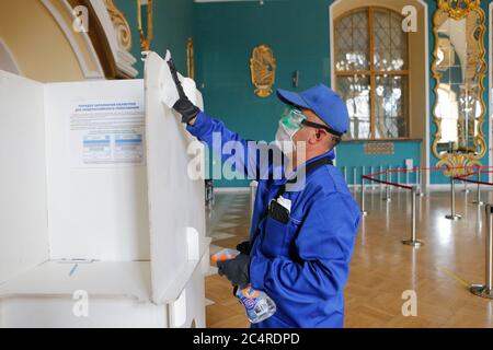 Moscow, Russia. 28th June, 2020. A worker wearing a face mask and gloves disinfects a stand at a polling station in Moscow, Russia, on June 28, 2020. The all-Russian vote on constitutional amendments, postponed from April 22 due to the COVID-19 epidemic, began on June 25. Voting was originally scheduled to run for one day only on July 1, but election officials opened polls a week earlier to avoid overcrowding that could spread coronavirus infections. Credit: Alexander Zemlianichenko Jr/Xinhua/Alamy Live News Stock Photo