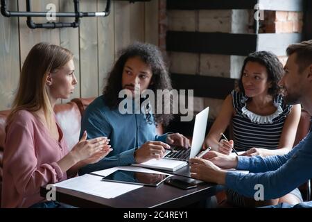 Employees during lunch in cafe working on common project Stock Photo