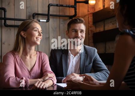 Professional wedding planner with bride and groom negotiating in cafe Stock Photo