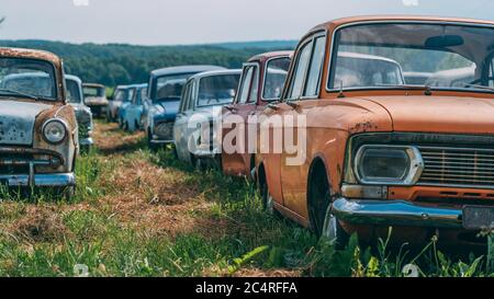 Many old abandoned and forgotten rusty vintage retro car in bad condition, panoramic view. Stock Photo