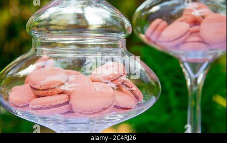 Close-up shot of pink macarons in glass jar. French pastries, candy bar Stock Photo