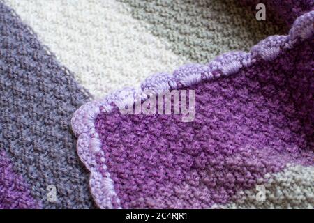 Purple, gray, and white knitted blanket Stock Photo