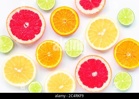 Various sliced citrus fruits: lime, orange, red and yellow grapefruit on a white background, texture. Stock Photo