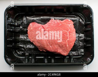 Above view of a top sirloin steak on black plastic Stock Photo