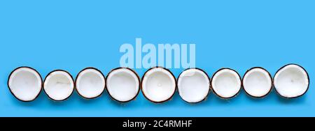 Half Coconuts on blue background. Copy space Stock Photo