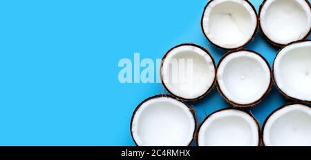 Half coconuts on blue background. Top view Stock Photo