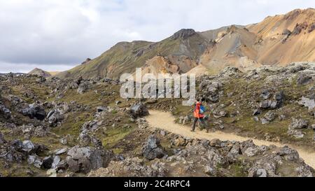 Young man hiking down the rocky trail in Landmannalaugar Stock Photo