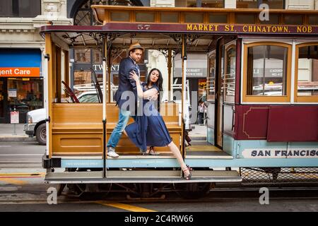 millenial couple dancing on a cable car in San Francisco. Stock Photo