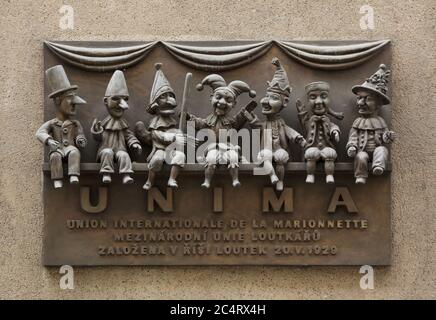 Commemorative plaque devoted to the UNIMA (Union Internationale de la Marionnette) on the building of the Puppet Empire Theatre (Divadlo Říše loutek) in Žatecká Street in Staré Město (Old Town) in Prague, Czech Republic. The International Puppetry Association was established in this theatre on 20 May 1929. Traditional national puppets are depicted on the plaque designed by Czech sculptor Bohumír Koubek and unveiled in 1979. Belgian Tchantchès, Italian Pulcinella, English Punch, Czech Kašpárek, Russian Petrushka, French Guignol and German Kasperl are depicted from left to right. Stock Photo