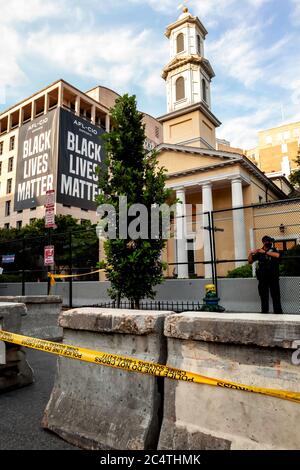 A large chain link fence, barriers, and police tape surround St. John's Episcopal Church at Black Lives Matter Plaza, Washington, DC, United States Stock Photo