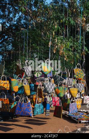 Colorful purses hanging from a tree at the FEIMA flea market in Maputo, Mozambique Stock Photo