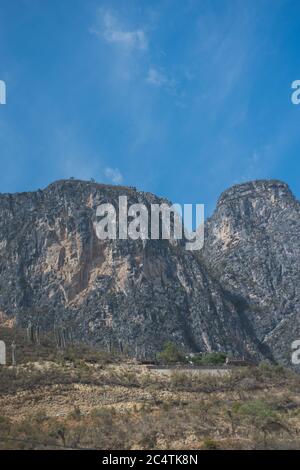 A vertical shot of a rocky hill under a starry night sky highlighting ...