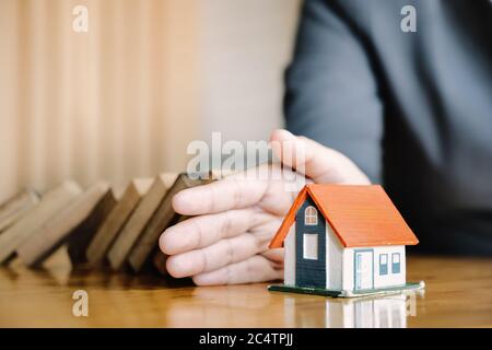 Protect the house from falling over the wooden blocks, Insurance and risk concept. Stock Photo