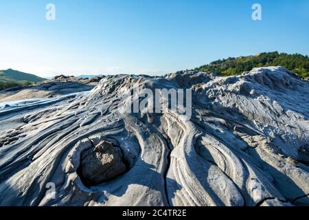 traveling to the muddy volcanoes we admire the lava and the arid earth on a beautiful summer day Stock Photo