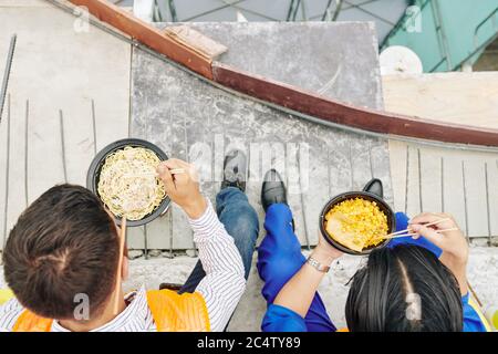 Workers having delicious dishes for lunch right at construction site, view from above Stock Photo
