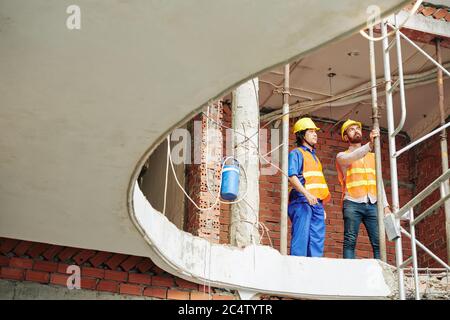 Engineer and contractor inspecting construction site and checking quality of installed pipes Stock Photo